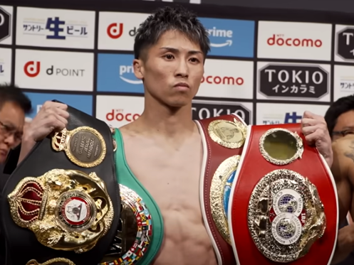 Boxing champion Naoya Inoue poses with his many world title belts